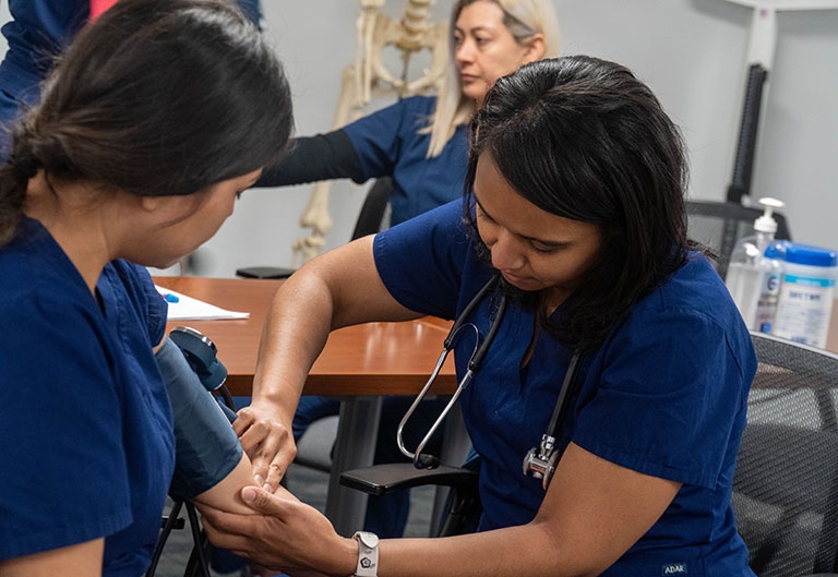 Medical workforce training students taking blood pressure