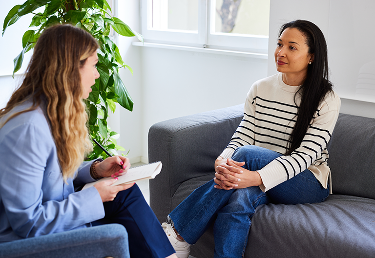 Counselor listening and taking notes while speaking to client