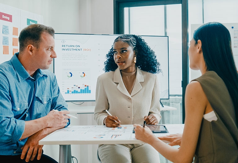 Market researchers in meeting, looking at/discussing statistics