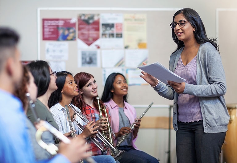 Music teacher instructing student musicians