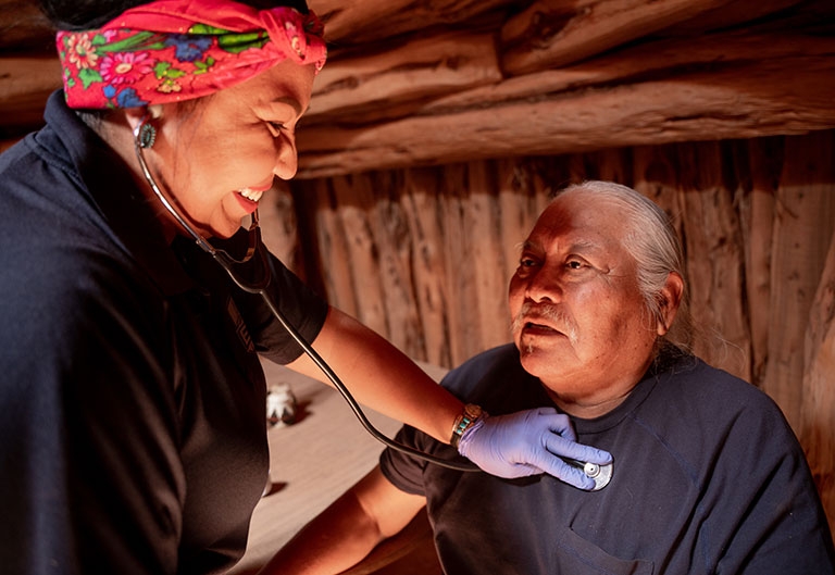 Nurse listening to patient breathing via a stethoscope
