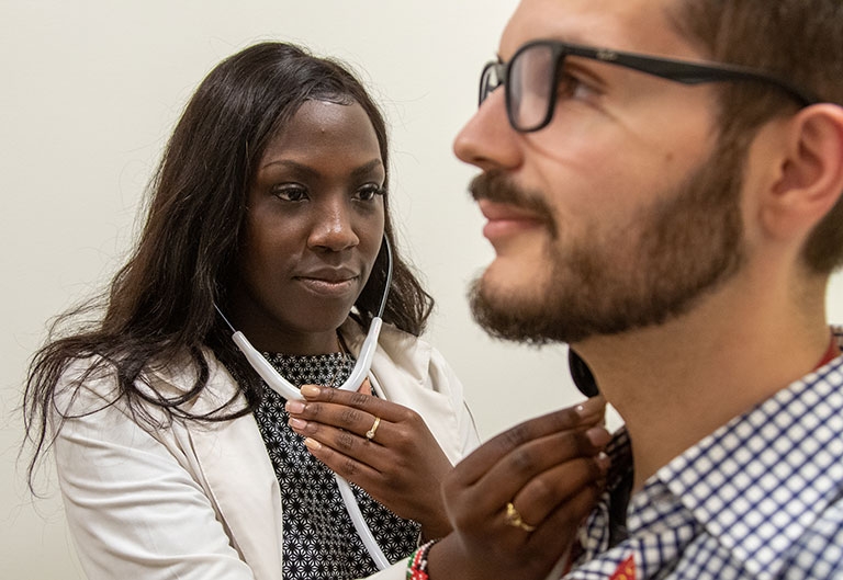 Nursing student listening to a patient with a stethoscope