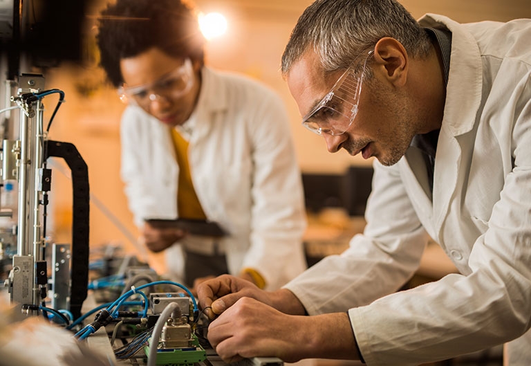 Scientists working in lab with wires and machines