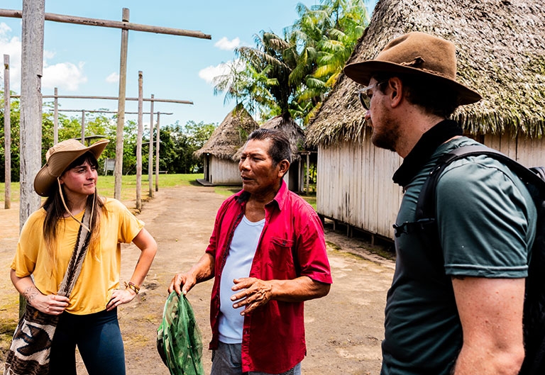 Visitors speaking with a local man in village