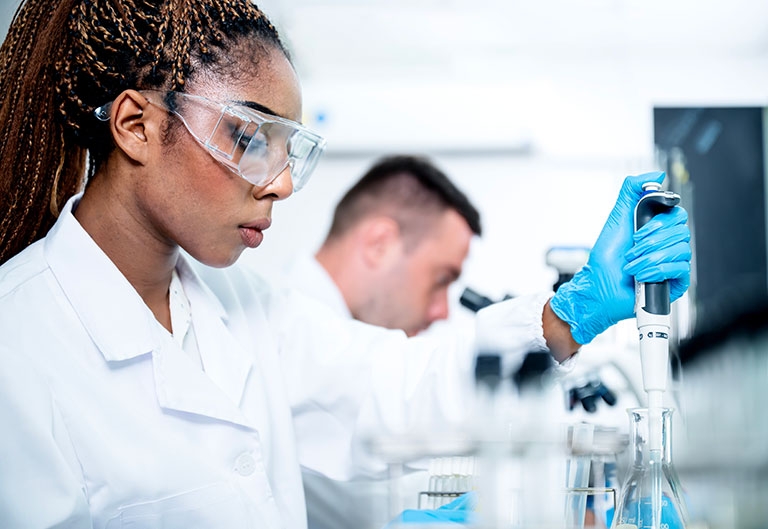 Woman working in goggles in lab, with substance