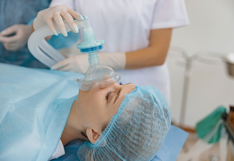 Nurse administering anesthesia to patient