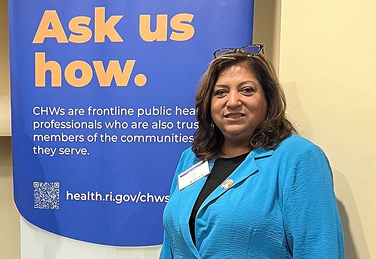 Woman standing in front of an "Ask us how." sign