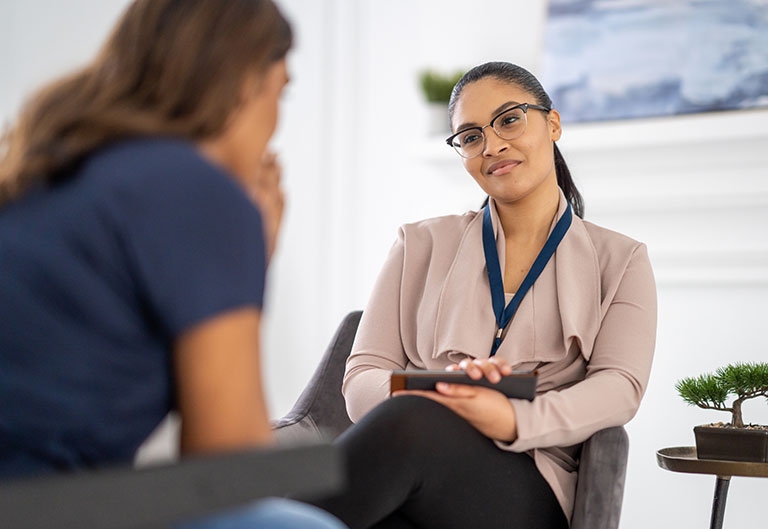 Mental health professional sitting opposite client, listening kindly