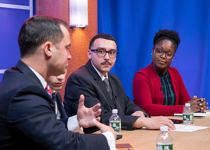Raymond Baccari sitting with guests at Anchor newsdesk