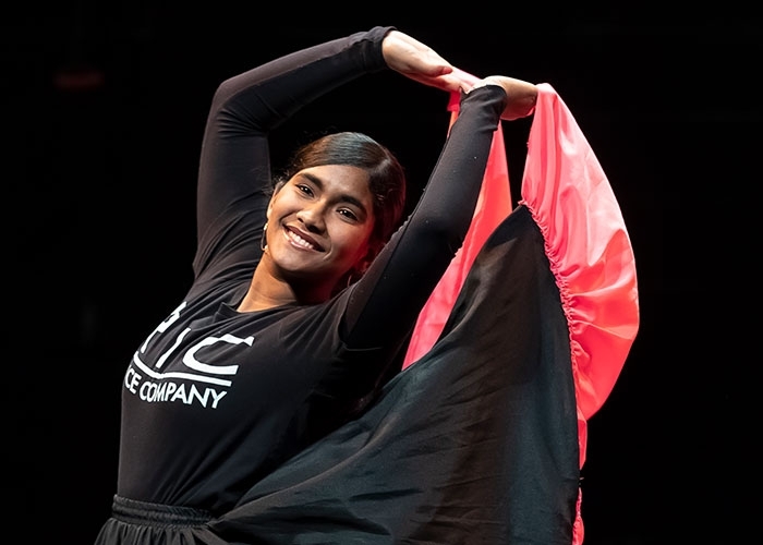 Dance major, Andreina Mendoza in motion, holding up train of her costume