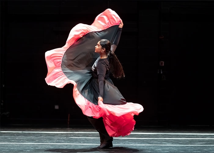 Dance major, Andreina Mendoza in profile with costume rippling around her