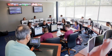 Professor in classroom with business students at computers
