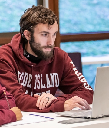 Student at laptop in RIC sweatshirt