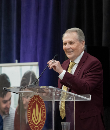 President Jack R. Warner on stage at podium