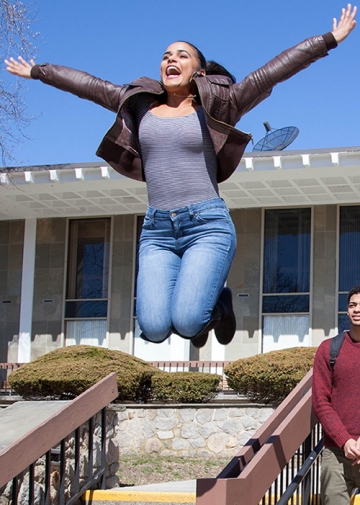 Student excited and jumping in air