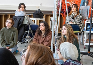 Students sitting listening in an art studio