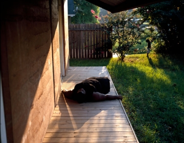 person laying on wooden landing