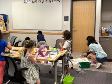 Young children working on crafts at tables