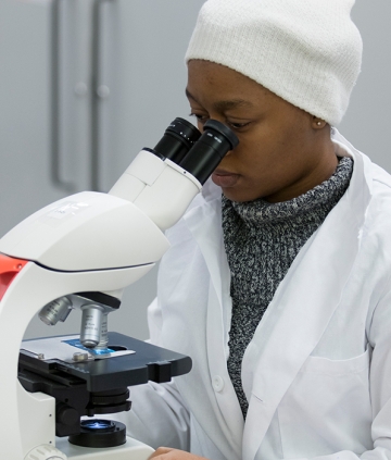 Biology student looking through microscope