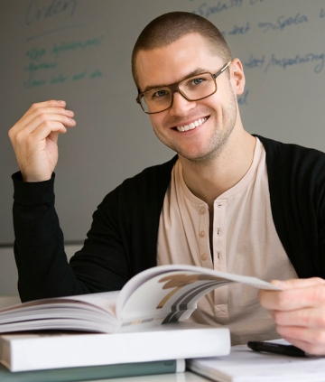 Graduate student studying and smiling