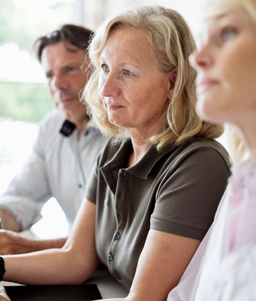 Older woman working with colleagues at a table