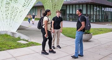 Students talking near sculpture