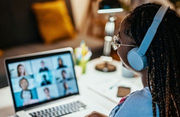 Woman at laptop on zoom call with nine people