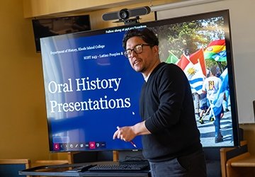 Person standing in front of a screen that says oral history presentations