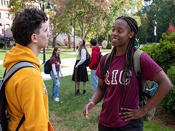 Students talking on campus on a sunny, fall day