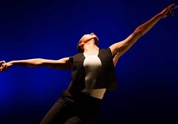 Student dancing dramatically in spotlight