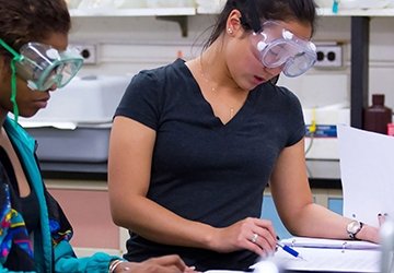 Students in goggles working in chemistry lab