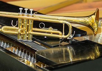 Trumpet resting on piano