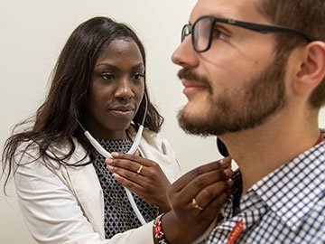 Nursing student listening to a patient with a stethoscope