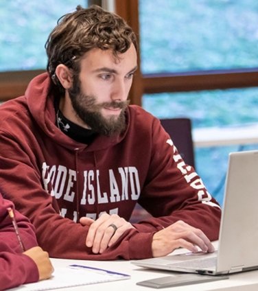 Student at laptop in RIC sweatshirt
