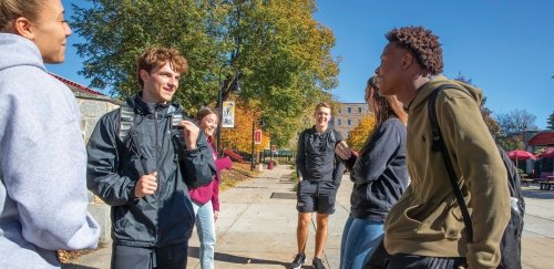 Five students talking outside on the quad