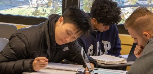 Three financial management students working at a table