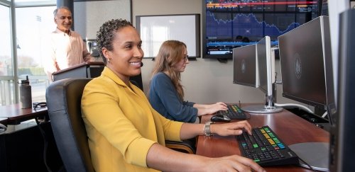 Two students in Finance Lab, professor in background