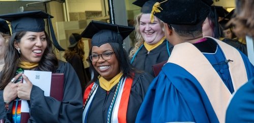 Group of graduates happily leaving commencement ceremony
