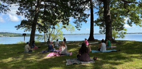 Rhode Island Writing Project event attendees, sitting in group, on blankets, by the water