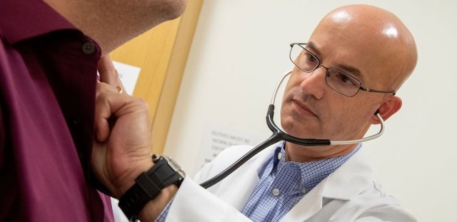 Graduate nursing student listening to patient breathing