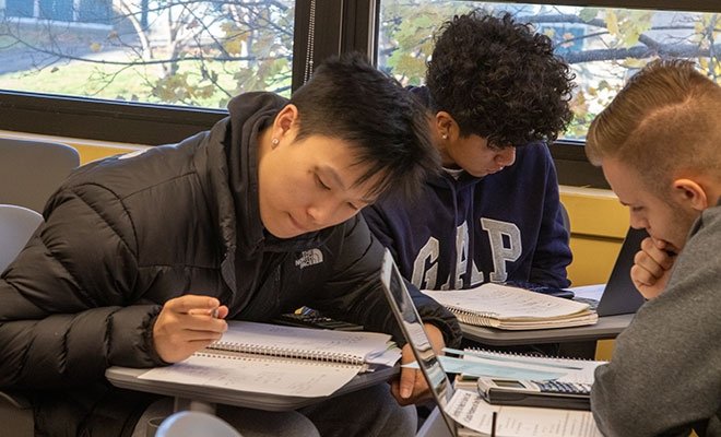 Three financial management students working at a table