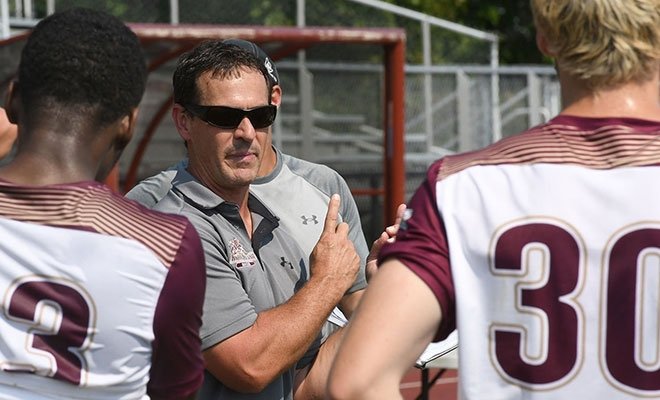 Coach with players on field, sports management