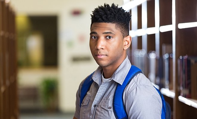 Black male student with backpack on