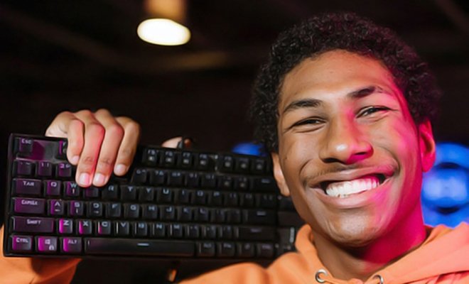 GenCyber Camp student smiling and holding up a keyboard