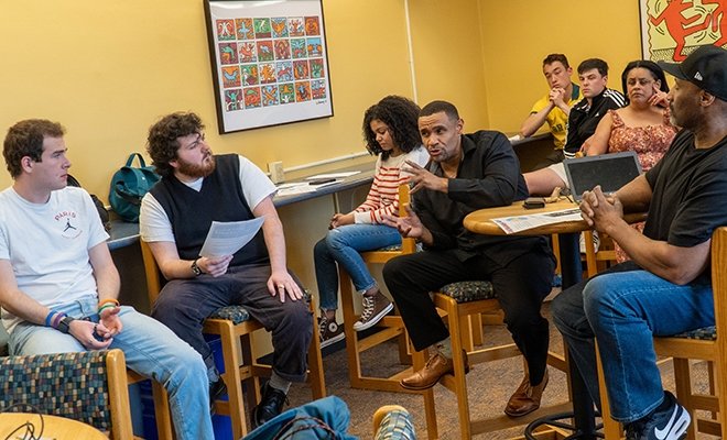 A group of history students in discussion at high tables