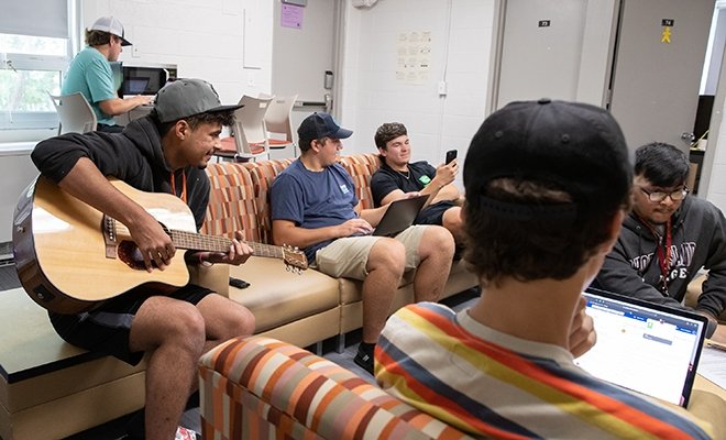 Male students hanging out, bonding in a dorm common area