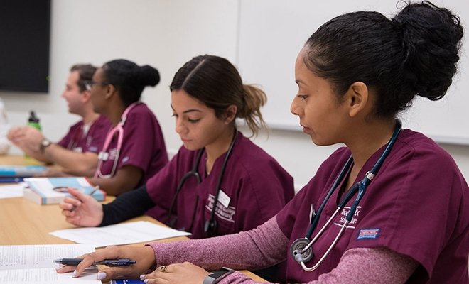 Nursing students in scrubs in class