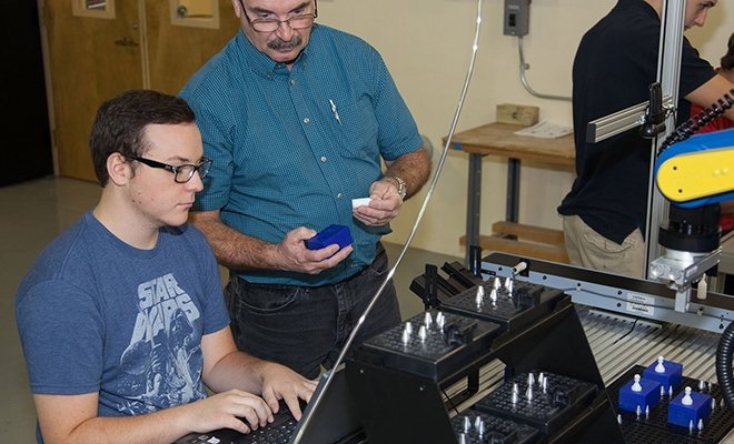 Professor and students working in the Tech Center at RIC
