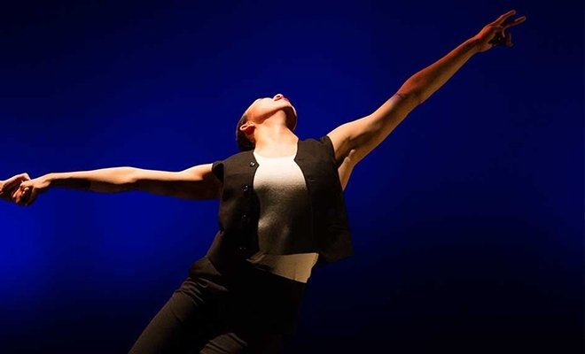 Student dancing dramatically in spotlight