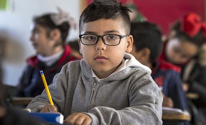 Young student writing in class